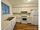 Galley kitchen with white cabinets, stainless steel appliances and wood flooring at 3312 Heathstead Pl, Charlotte, NC 28210