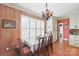 Kitchen dining area with wood-paneled walls and white shutters at 206 N Trexler Ave, Rockwell, NC 28138