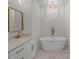 Elegant bathroom featuring a standalone tub, modern vanity, gold fixtures, and a unique light fixture at 2410 Brantley Rd, Kannapolis, NC 28083