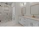 Bright bathroom featuring double sinks, white marble floors, and glass enclosed shower at 2410 Brantley Rd, Kannapolis, NC 28083