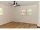 Bright bedroom with ceiling fan, hardwood floors, and window shutters at 6372 Morehead Rd, Harrisburg, NC 28075