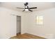 Well-lit bedroom with ceiling fan, closet, and window shutters at 6372 Morehead Rd, Harrisburg, NC 28075