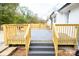 Gray composite deck with wooden railings and steps at 6372 Morehead Rd, Harrisburg, NC 28075