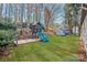 Lush backyard features a swing set, slide set, storage shed, and mature trees at 9027 Twin Trail Dr, Huntersville, NC 28078