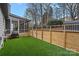 Backyard features a fenced artificial-turfed lawn, a screened-in porch, mature trees, and storage shed at 9027 Twin Trail Dr, Huntersville, NC 28078