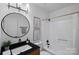 Bathroom features a black marble sink, a circular mirror, and a combined shower and tub with updated fixtures at 9027 Twin Trail Dr, Huntersville, NC 28078