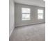 Bright bedroom with gray carpeting and two large windows at 105 Ciara Pl # A, Mooresville, NC 28117