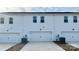 Row of attached garages with white doors and modern lighting, set against a backdrop of white siding at 105 Ciara Pl # B, Mooresville, NC 28117