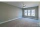 Spacious bedroom with large windows and a ceiling fan, featuring neutral walls and carpet at 1865 Rock Hill Church Rd # 3, Matthews, NC 28104