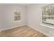 Sunlit bedroom featuring two large windows and stylish wood-look flooring at 305 Pawley Dr, Charlotte, NC 28214