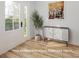 Bright foyer featuring wood-look floors, a stylish sideboard, and a decorative olive tree at 305 Pawley Dr, Charlotte, NC 28214