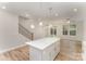 Open concept kitchen featuring an island, stairs, and hardwood flooring that connects to the living space at 305 Pawley Dr, Charlotte, NC 28214