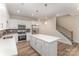 Eat-in kitchen features a center island, stainless appliances, and staircase access at 305 Pawley Dr, Charlotte, NC 28214