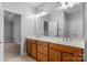 Bathroom featuring double sinks with wood cabinetry and a large mirror at 8336 Indigo Row, Charlotte, NC 28277