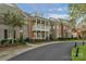 Attractive brick townhouse with a balcony, complemented by lush landscaping and a winding road at 8336 Indigo Row, Charlotte, NC 28277