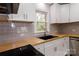 Modern kitchen with white cabinets and gray tile backsplash at 8724 Old Plank Rd, Charlotte, NC 28216