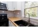 Updated kitchen featuring butcher block countertops and gray tile backsplash at 8724 Old Plank Rd, Charlotte, NC 28216