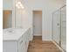 Bathroom with double sinks, wood-look flooring and a glass enclosed shower at 1150 Red River Dr, Salisbury, NC 28144