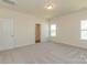 Bedroom featuring two windows, neutral carpet, and access to a closet at 1150 Red River Dr, Salisbury, NC 28144