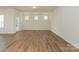 Bright living room featuring hardwood floors, white walls, and multiple windows for natural light at 1150 Red River Dr, Salisbury, NC 28144
