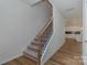 Carpeted staircase with wood and metal railing, leading to an open kitchen at 1150 Red River Dr, Salisbury, NC 28144