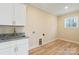 Laundry room with white cabinets, granite countertop and sink at 13000 John Bostar Ln, Charlotte, NC 28215