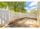 Charming backyard featuring a patio, and a white picket fence surrounded by trees and greenery at 2702 New Hamlin Way, Charlotte, NC 28210