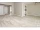Bright living room showcasing neutral walls and carpet with open access to other rooms at 2702 New Hamlin Way, Charlotte, NC 28210