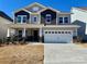 Two-story home featuring gray and blue siding, white trim, a two-car garage, and stone accents on the columns at 3031 Puddle Pond Rd, Indian Trail, NC 28079
