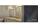 Bathroom featuring double sinks with granite counters, tiled walls and modern mirrors at 536 Robinhood Rd # 27, Maiden, NC 28650