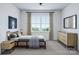 Modern bedroom featuring stylish furniture, decor, and a large window at 5676 Clear Creek Ln, Charlotte, NC 28215