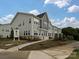 Exterior front view of newly built gray townhomes with sidewalk and landscaping at 5676 Clear Creek Ln, Charlotte, NC 28215