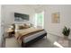 Well-lit bedroom with a gray bed, stylish decor, and large window, creating a relaxing retreat at 7169 Chamberlain Dr, Harrisburg, NC 28075