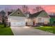 Charming one-story home with a two-car garage, green and white siding, brick accents, and a well-manicured lawn at 7169 Chamberlain Dr, Harrisburg, NC 28075