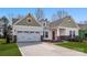 Charming one-story home with a two-car garage, green and white siding, brick accents, and a well-manicured lawn at 7169 Chamberlain Dr, Harrisburg, NC 28075