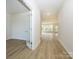 Bright hallway with wood-look flooring leading to a well-lit room with a wall of windows and a glass-paneled door at 7169 Chamberlain Dr, Harrisburg, NC 28075