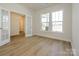 Bright room featuring hardwood floors, french doors, and a large window with neighborhood views at 7169 Chamberlain Dr, Harrisburg, NC 28075