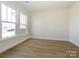 Sunlit room featuring hardwood floors and large windows for ample natural light at 7169 Chamberlain Dr, Harrisburg, NC 28075