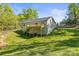 Rear exterior showing a deck and walkout basement on a sloped lot bordered by mature trees at 3146 Captains Cove Ln, Lincolnton, NC 28092