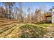 Spacious backyard with a gentle slope, green grass, mature trees, and deck at 3146 Captains Cove Ln, Lincolnton, NC 28092