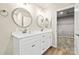 Bright bathroom featuring a double sink vanity with a marble countertop and framed mirrors and a walk-in closet at 3146 Captains Cove Ln, Lincolnton, NC 28092