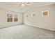 Bedroom features carpeted floors, three windows providing natural light, and a ceiling fan at 3146 Captains Cove Ln, Lincolnton, NC 28092