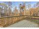 A view from the deck showcasing the surrounding trees, wooden railing, and flooring at 3146 Captains Cove Ln, Lincolnton, NC 28092