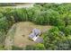 Aerial view of a luxurious home near a lake, surrounded by lush trees and a well-manicured lawn at 3678 Rankin Rd, Concord, NC 28027