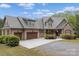 Elegant home featuring a three-car garage, stone accents, and a beautifully landscaped front yard at 3678 Rankin Rd, Concord, NC 28027