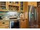 Close-up of a kitchen with wood cabinets, granite countertops, and stainless steel appliances at 3678 Rankin Rd, Concord, NC 28027