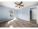 Bright bedroom features light blue walls, wood-look flooring, and a ceiling fan at 108 W Maryland Ave, Bessemer City, NC 28016