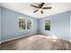 Bright bedroom with hardwood floors, ceiling fan, and three large windows at 108 W Maryland Ave, Bessemer City, NC 28016