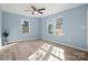 Light-filled bedroom with a ceiling fan, hardwood floors, and soft blue walls at 108 W Maryland Ave, Bessemer City, NC 28016