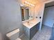 Bathroom with gray vanity, mirror with lights, toilet, and tile floors at 115 Turner St, Lincolnton, NC 28092